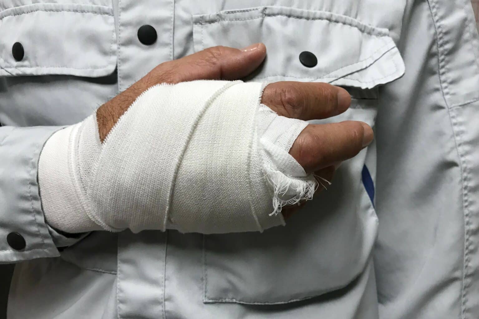 man in button up shirt with hand in bandages