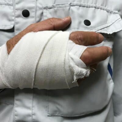 man in button up shirt with hand in bandages