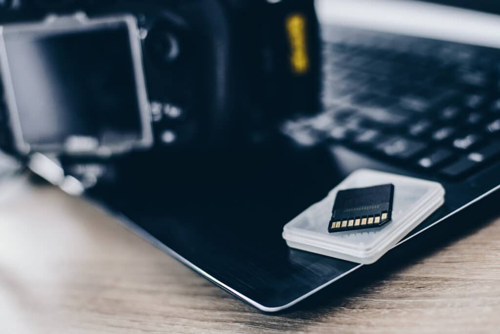 close-up of camera memory card on top of laptop