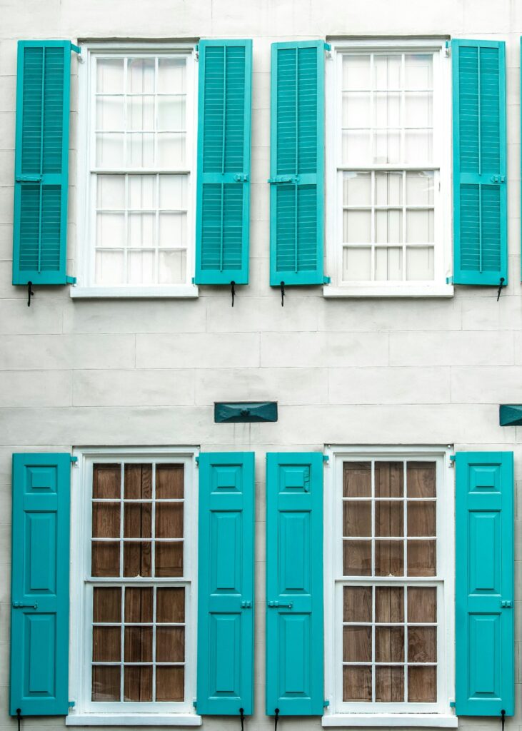 Front exterior of multi-story home with stacked windows and blue shutters, as one might see in a window inspection report.