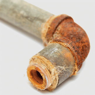 45 degree elbow pipe covered in red rust, representing Claim 5: Plumbing