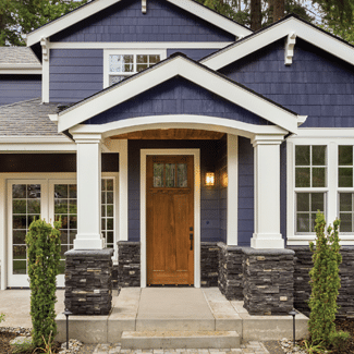 View of the front porch of a two-story, modern home, featuring navy-blue exterior, white pillars, and matching, opulent windows; representing Claim 12: Windows