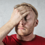 Man with blond hair and slight beard slapping his forehead with his hand in exaggeration, representing Avoiding the Top 12 Claims Against Home Inspectors