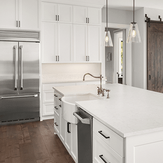 Spacious, modern kitchen with white cabinets and countertops. dark brown floors, and a silver fridge