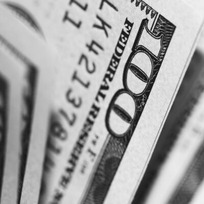 A stack of hundred dollar bills, alluding to questions about the first year inspecting like, do home inspectors make good money after starting a home inspector company?