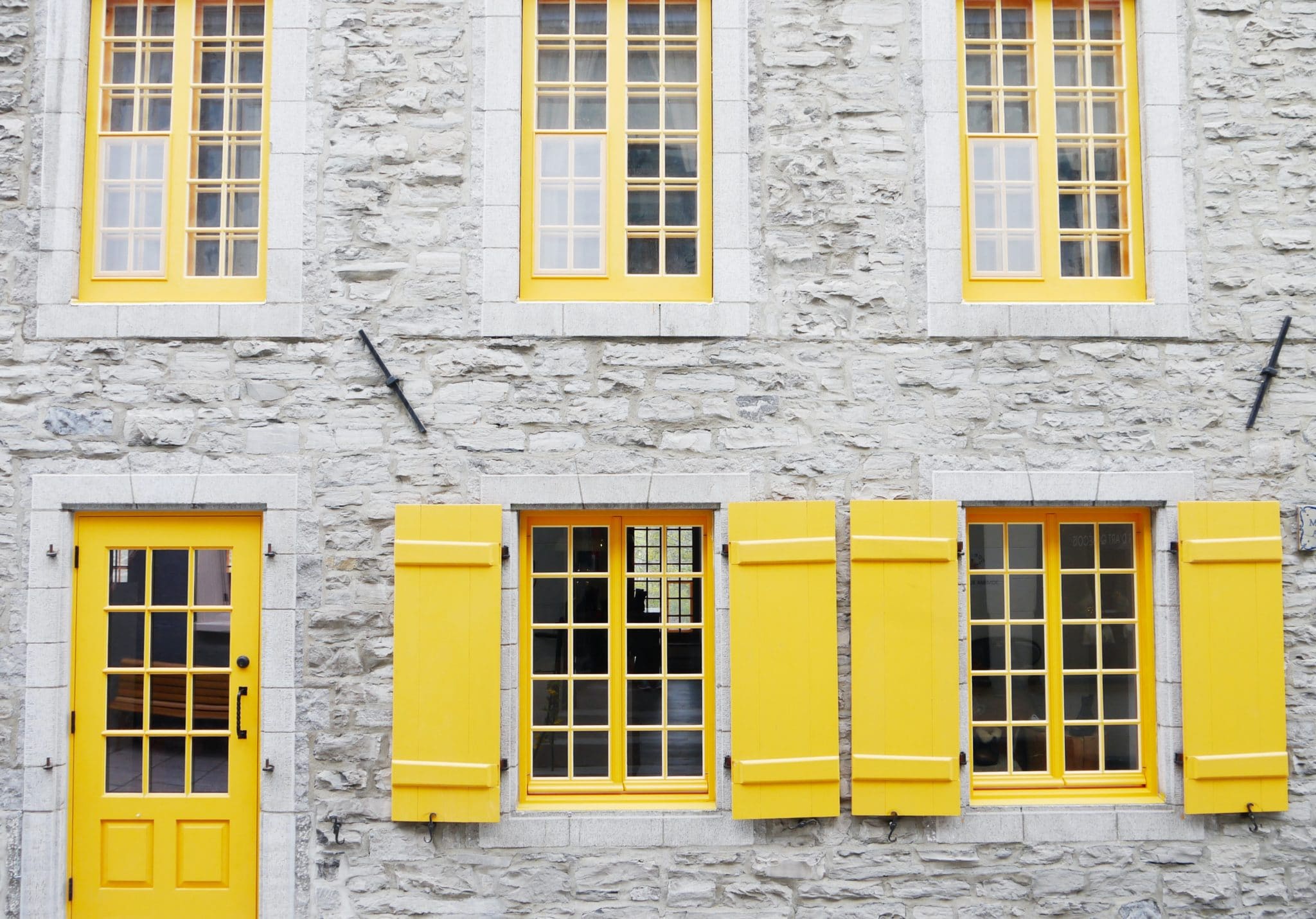 White, multi-story building with yellow windows and yellow door, signifying options for home inspection clients