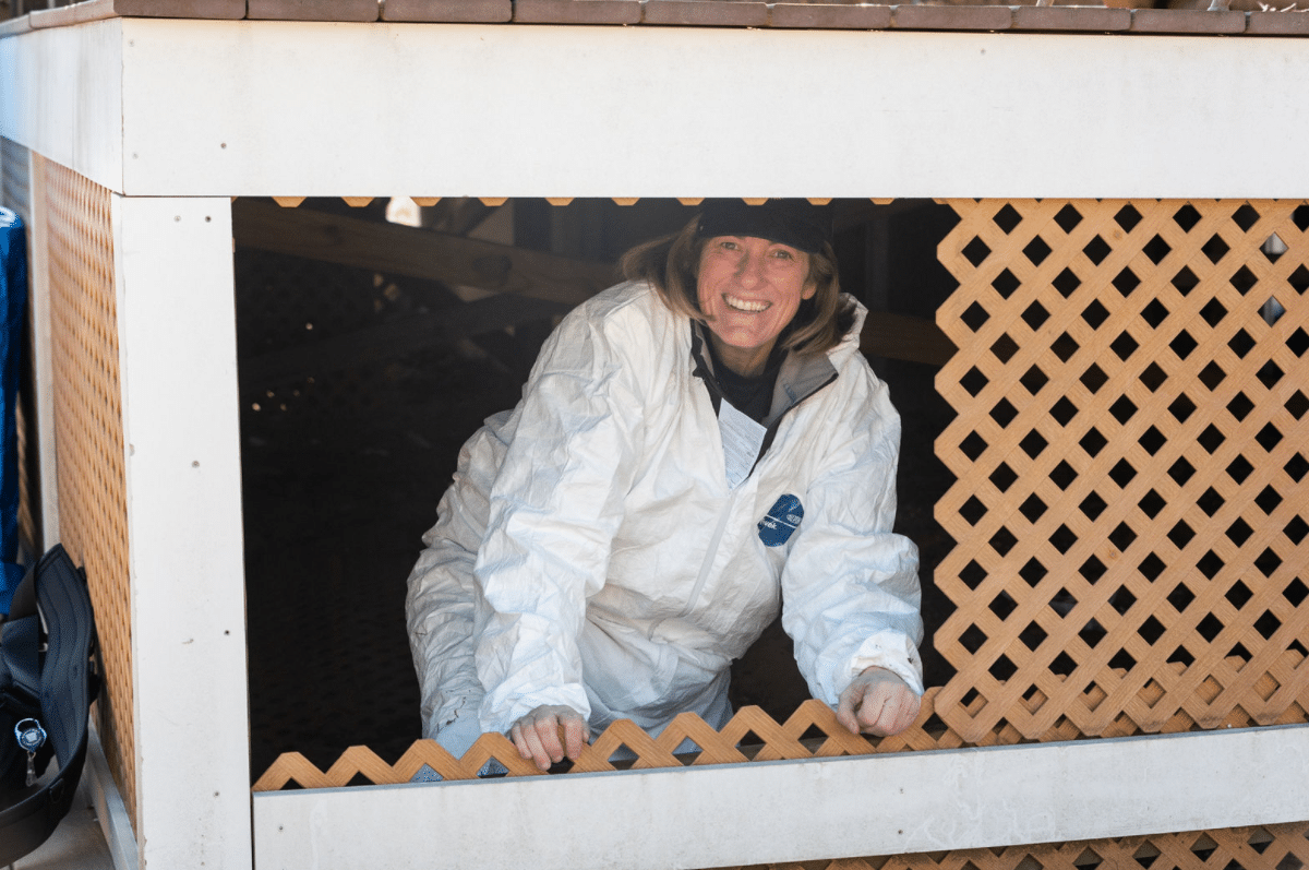 Alajajian Giroux smiling from a crawlspace during an inspection