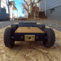 Close up of crawl bot moving toward camera, driving across plank of wood