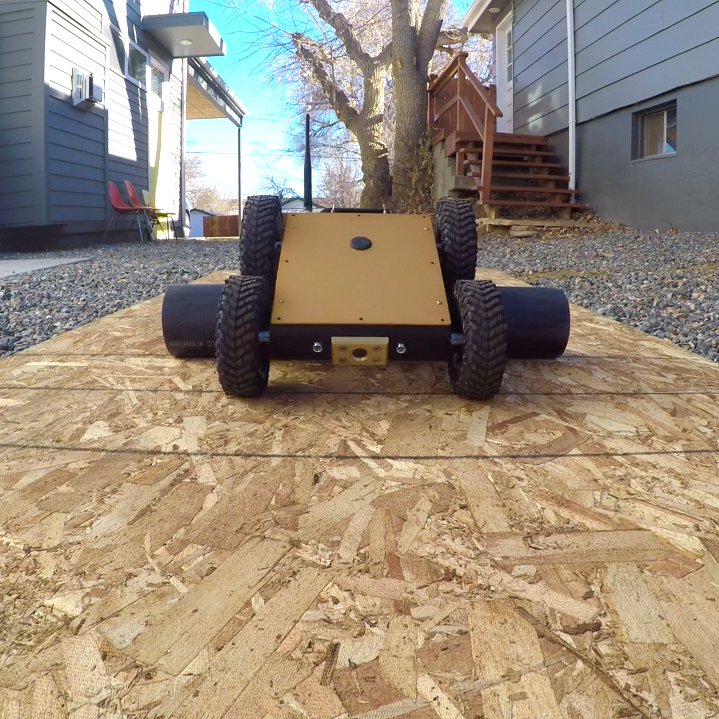 Crawlspace inspection rover crawling over a pipe.