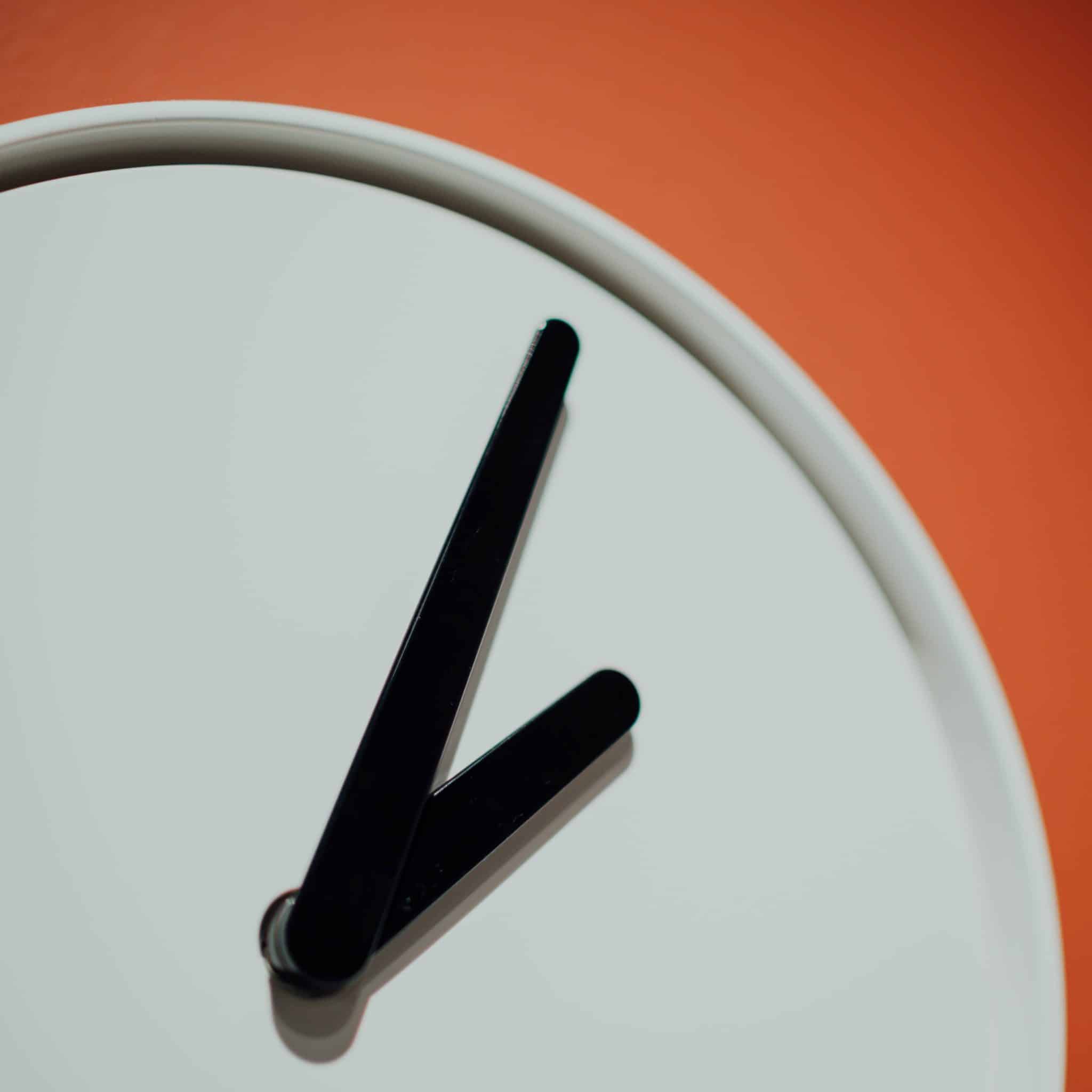 White clock with black hands against light-red background, indicating time frame for giving recommendations