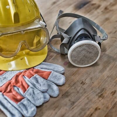 top view of personal protective equipment hardhat, googles, respirator, and gloves