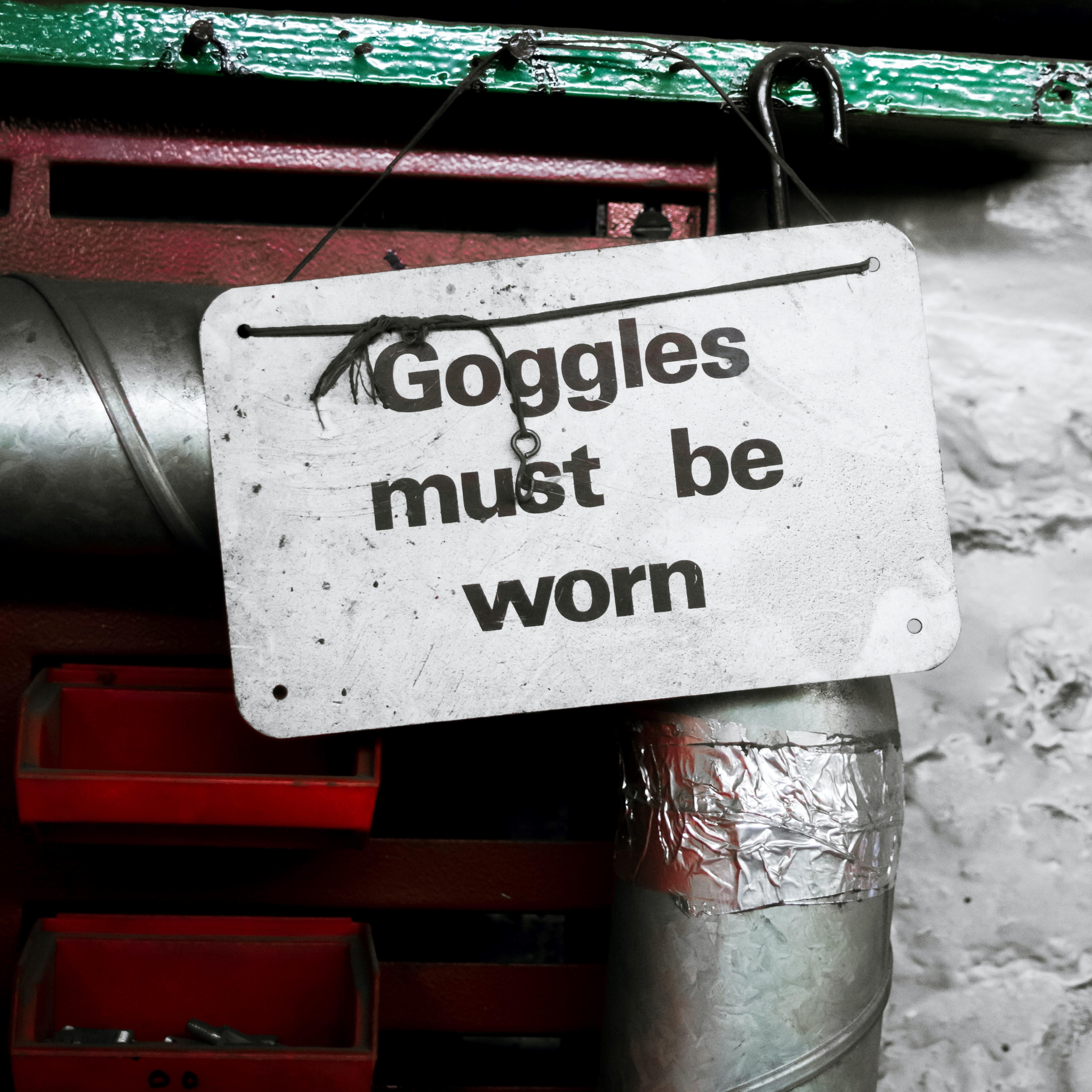 White sign with black text, "Goggles must be worn" - a reminder for home inspector to use PPE eye protection