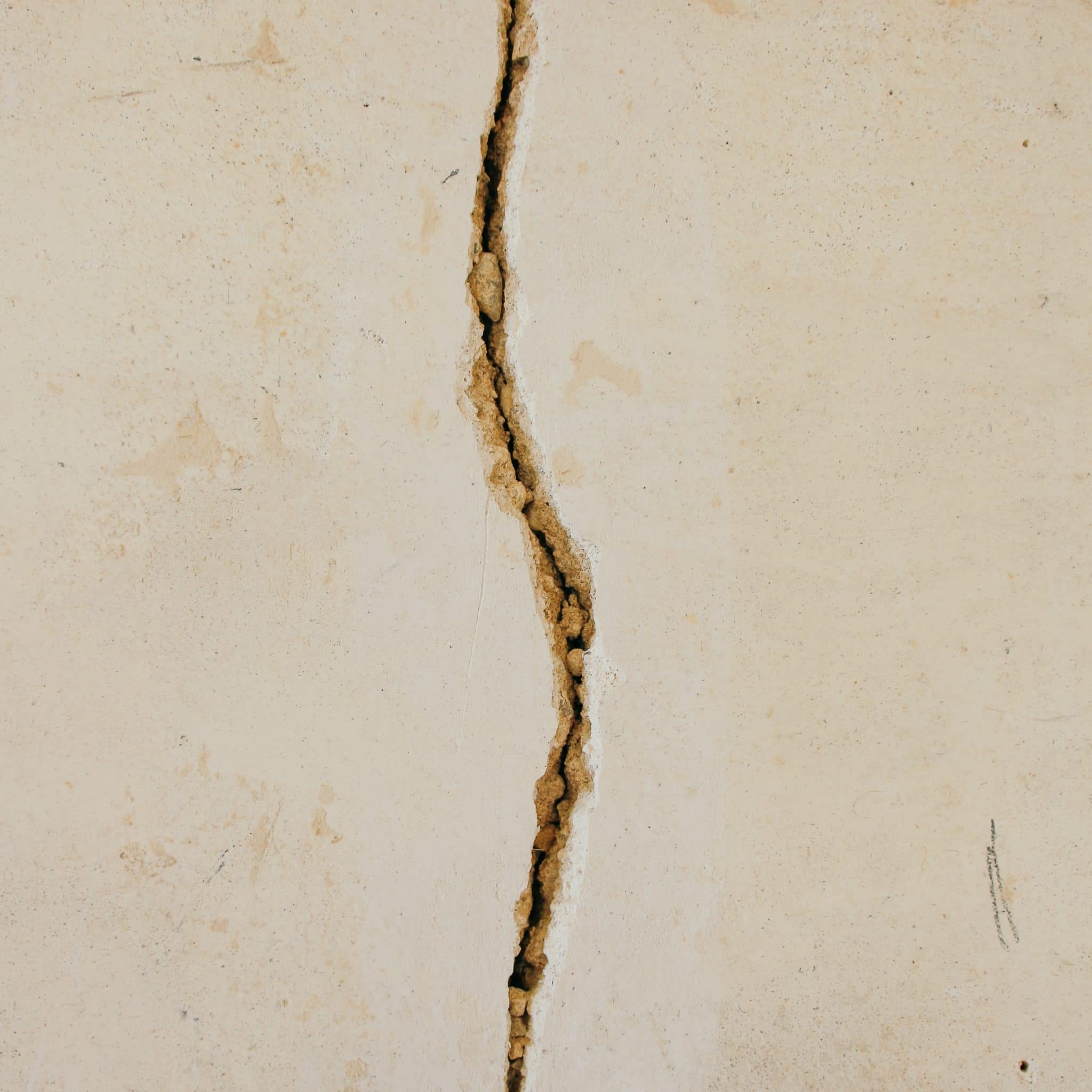 Tan wall with vertical foundation crack running down center