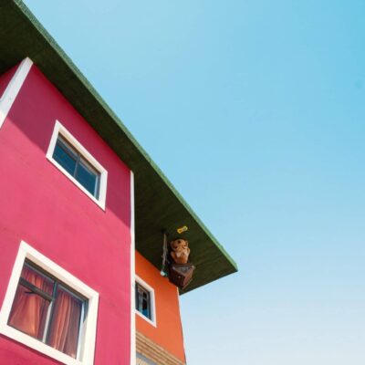 Red and orange house with illusion of being upside down, blue sky in background