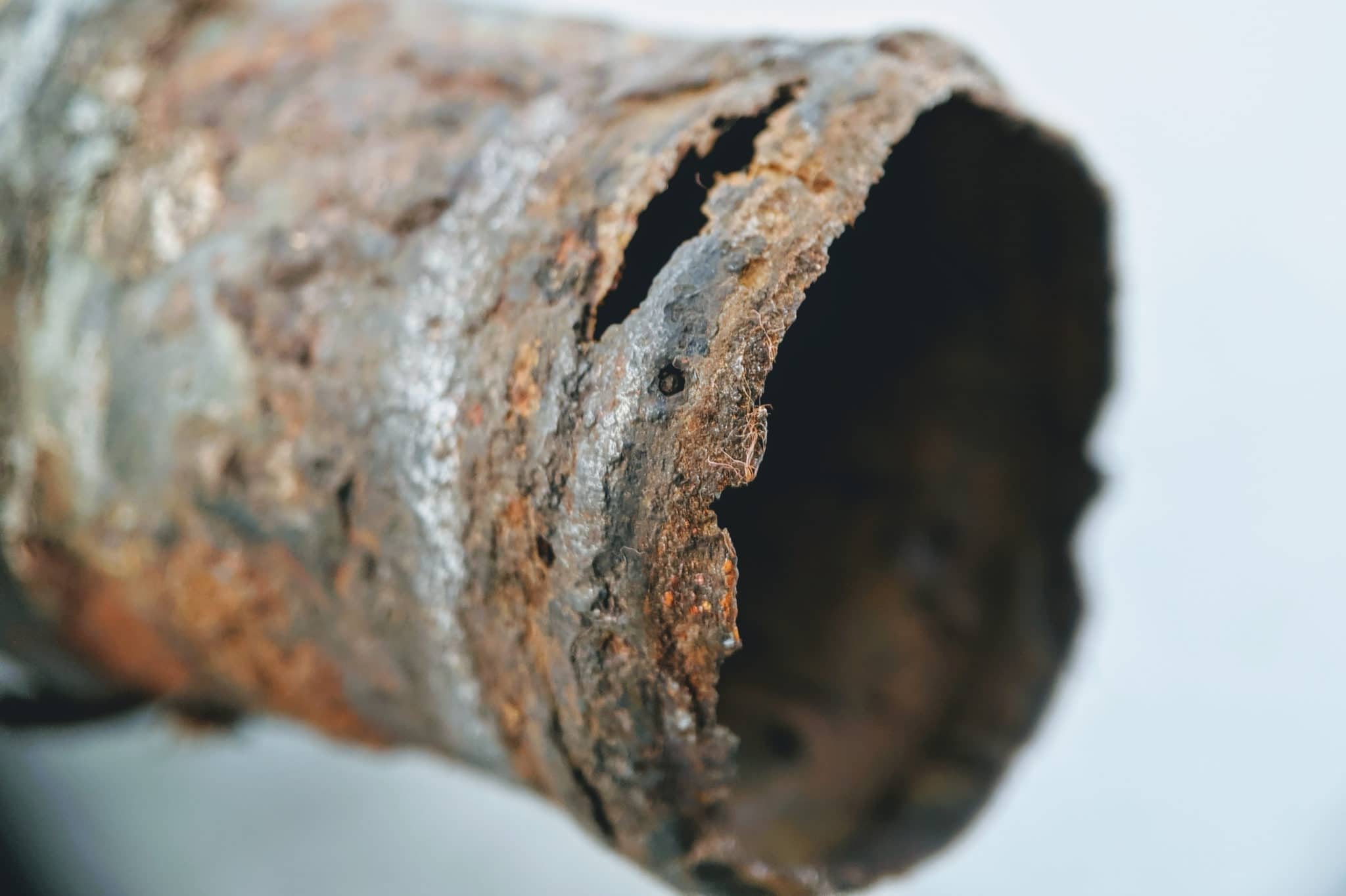 Rusted and cracked cast iron plumbing pipe