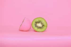 Kiwi, painted pink on the outside and normally colored green on the inside. Illustrates concept of concealed or hidden defects.