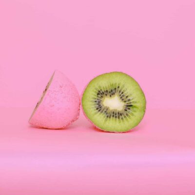 Kiwi, painted pink on the outside and normally colored green on the inside. Illustrates concept of concealed or hidden defects.