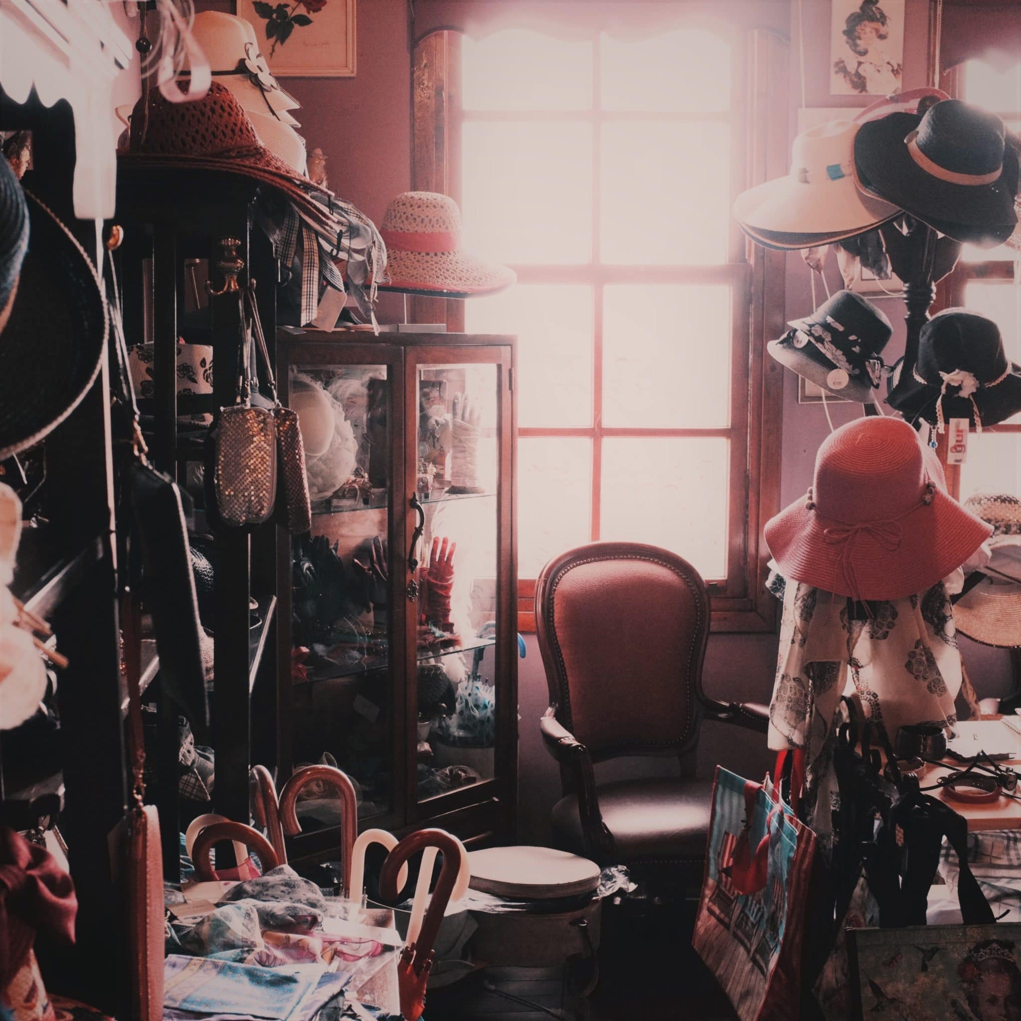 Cluttered house with furniture, hats, and other personal belongings strewn across the floor and on the walls