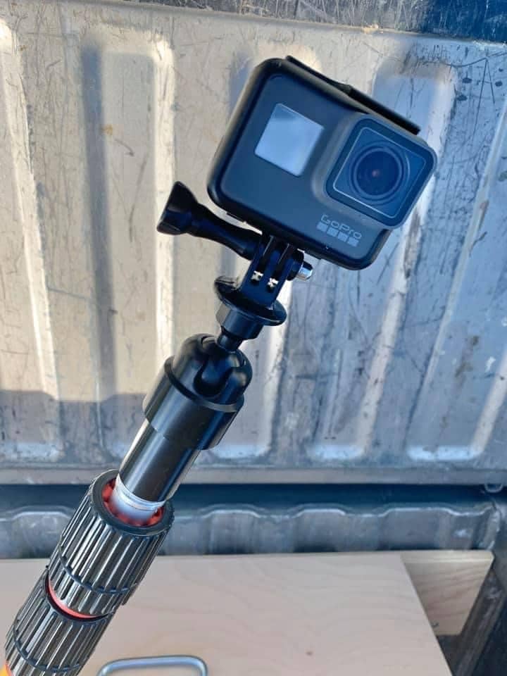 Black GoPro camera attached to a pole, used as a custom pole cam for home inspections