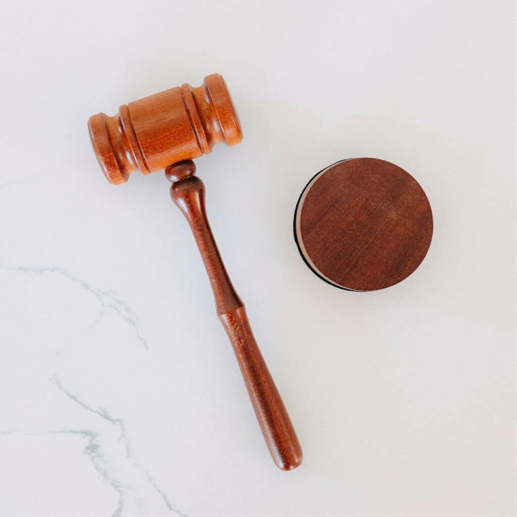 A wooden gavel on a white marble backdrop