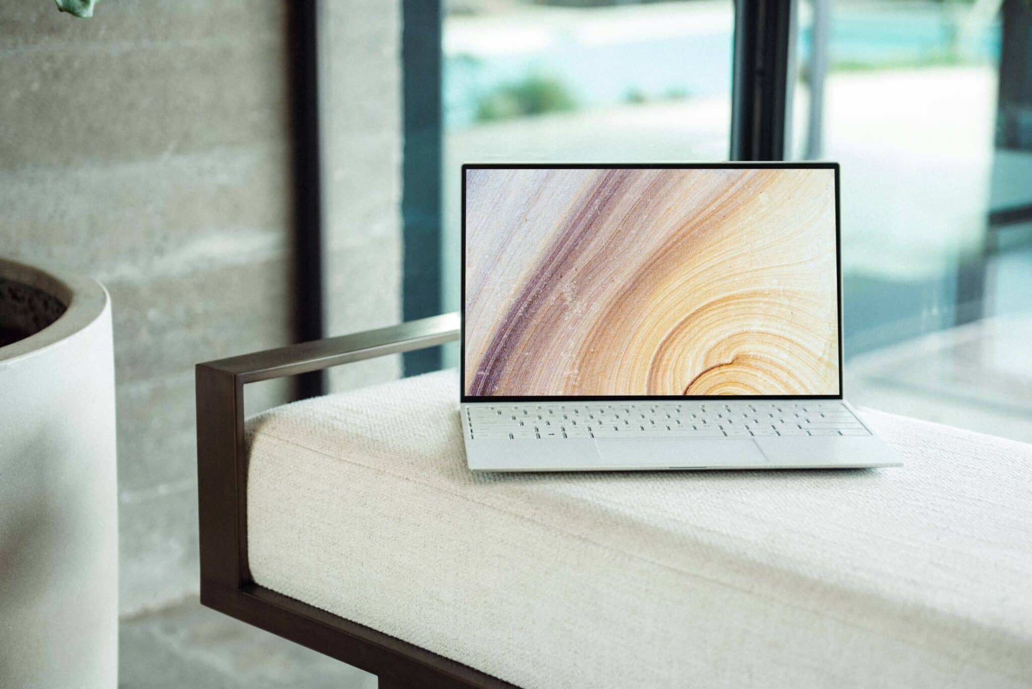 Open laptop on a fabric bench indoors