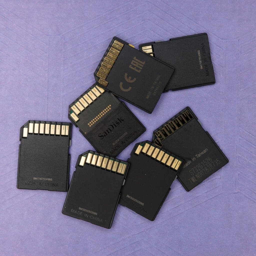 Black memory cartridges in a pile against a purple background