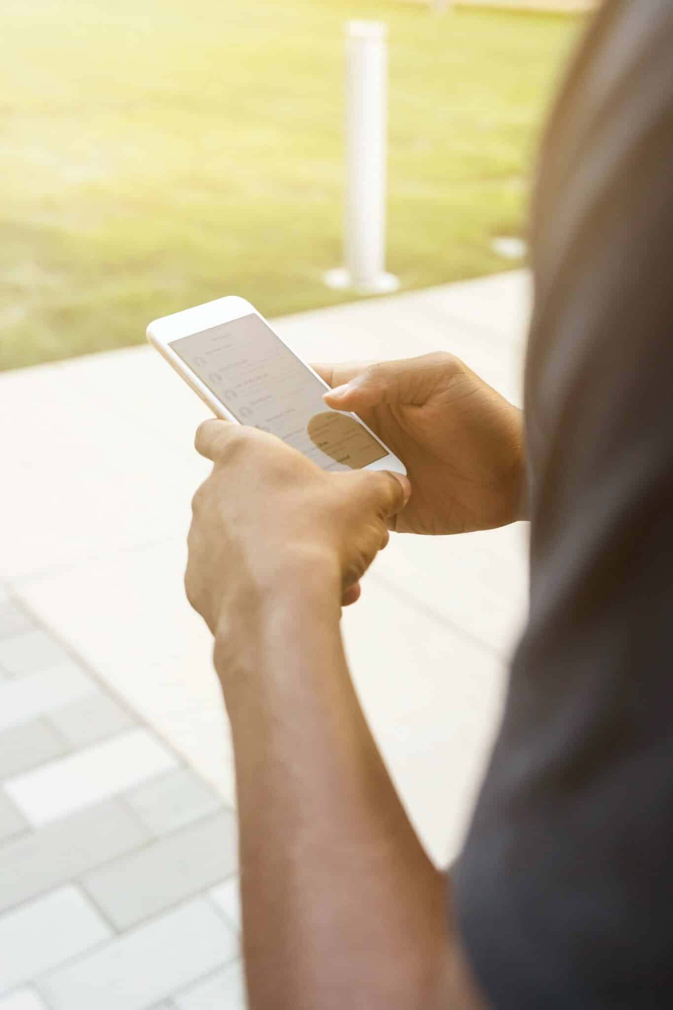 Man holding phone and scrolling through contacts