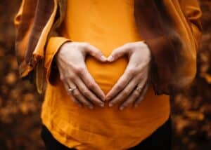 pregnant woman making heart shape with hands