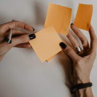 woman holding orange sticky notes