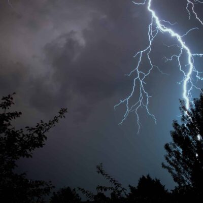Zoomed-in image of lightning strike at night. This is one of many conditions to watch out for while performing a home inspection during extreme weather.