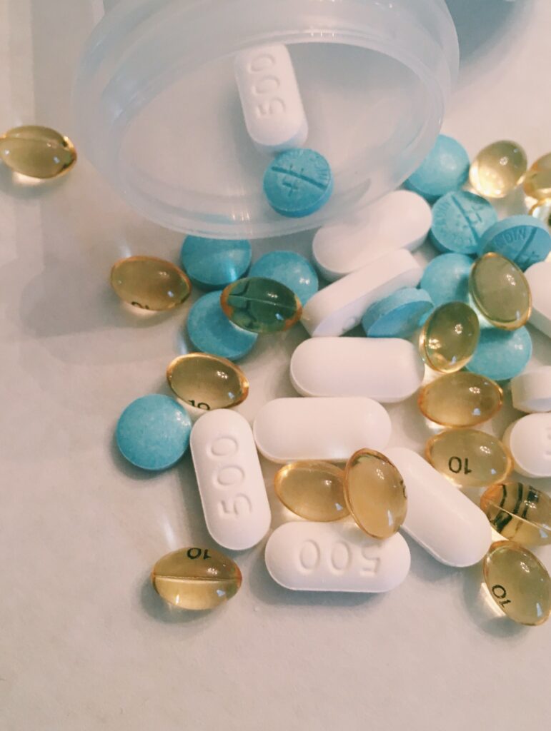 blue white and yellow pills spilling out of bottle