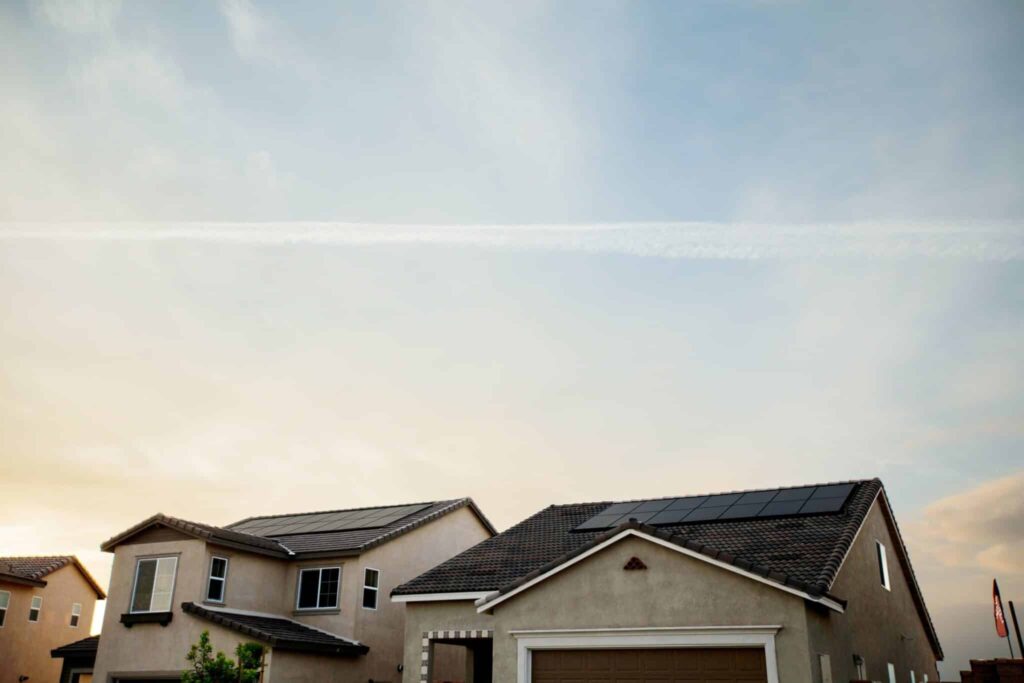 Rooftops in suburban neighborhood against a cloudy, sunset or sunrise sky. Ideal conditions for a morning roof inspection.