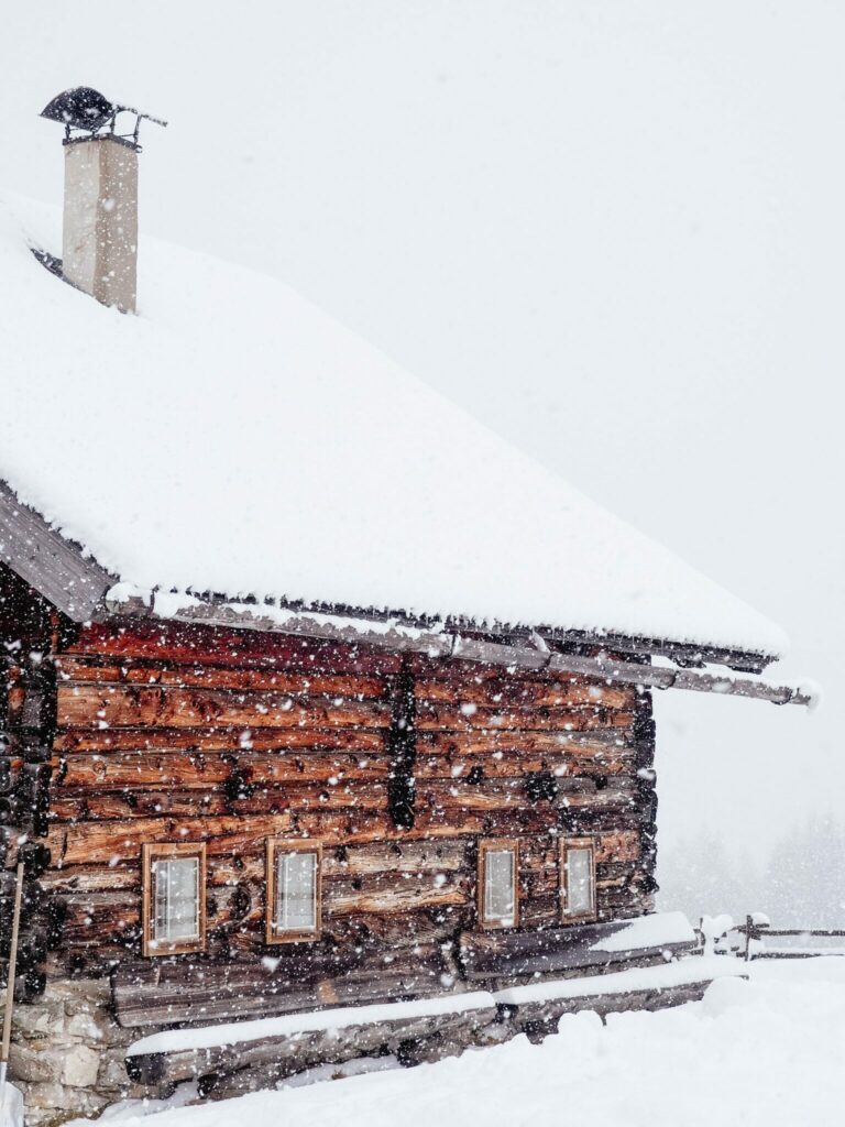 Log house with snow-covered roof, ground also blanketed with snow