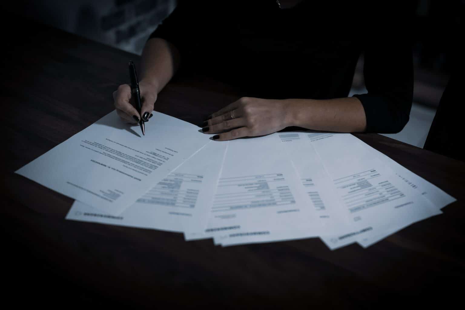 woman writing on documents