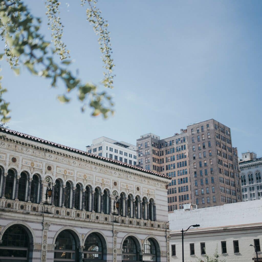 Learn how to become a home inspector in Alabama, and a city like Birmingham, as depicted in this tall, white, historical building amid other city buildings.