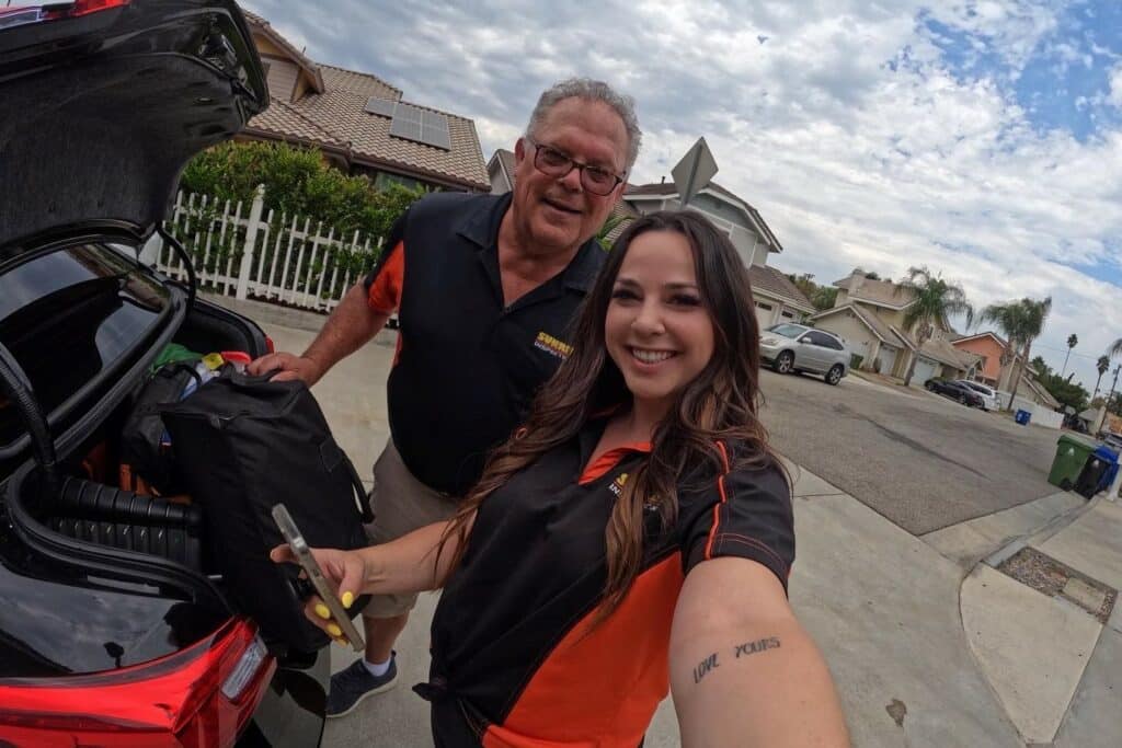 Man wearing glasses (Ed) and young woman (Rebecca) take a selfie together. This father-daughter duo manages a family home inspection business