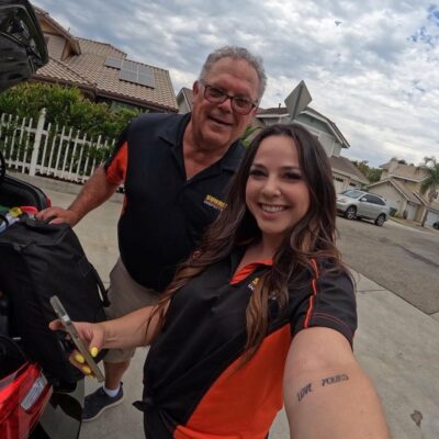 Man wearing glasses (Ed) and young woman (Rebecca) take a selfie together. This father-daughter duo manages a family home inspection business