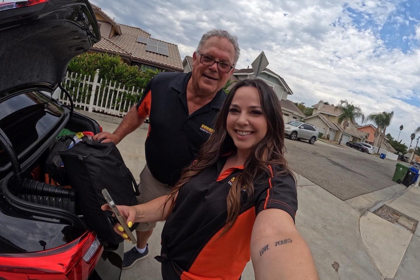 Ed-Rebecca-Father-Daughter-Duo Man wearing glasses (Ed) and young woman (Rebecca) take a selfie together. This father-daughter duo manages a family home inspection business