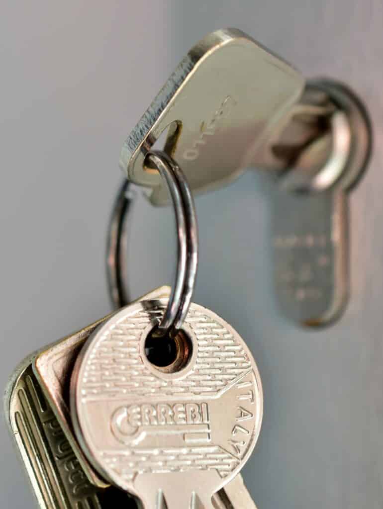 Metal key on a key ring used to unlock a door or box. Used to illustrate the idea of Supra real estate keys and home inspector responsibilities to lock up each property.