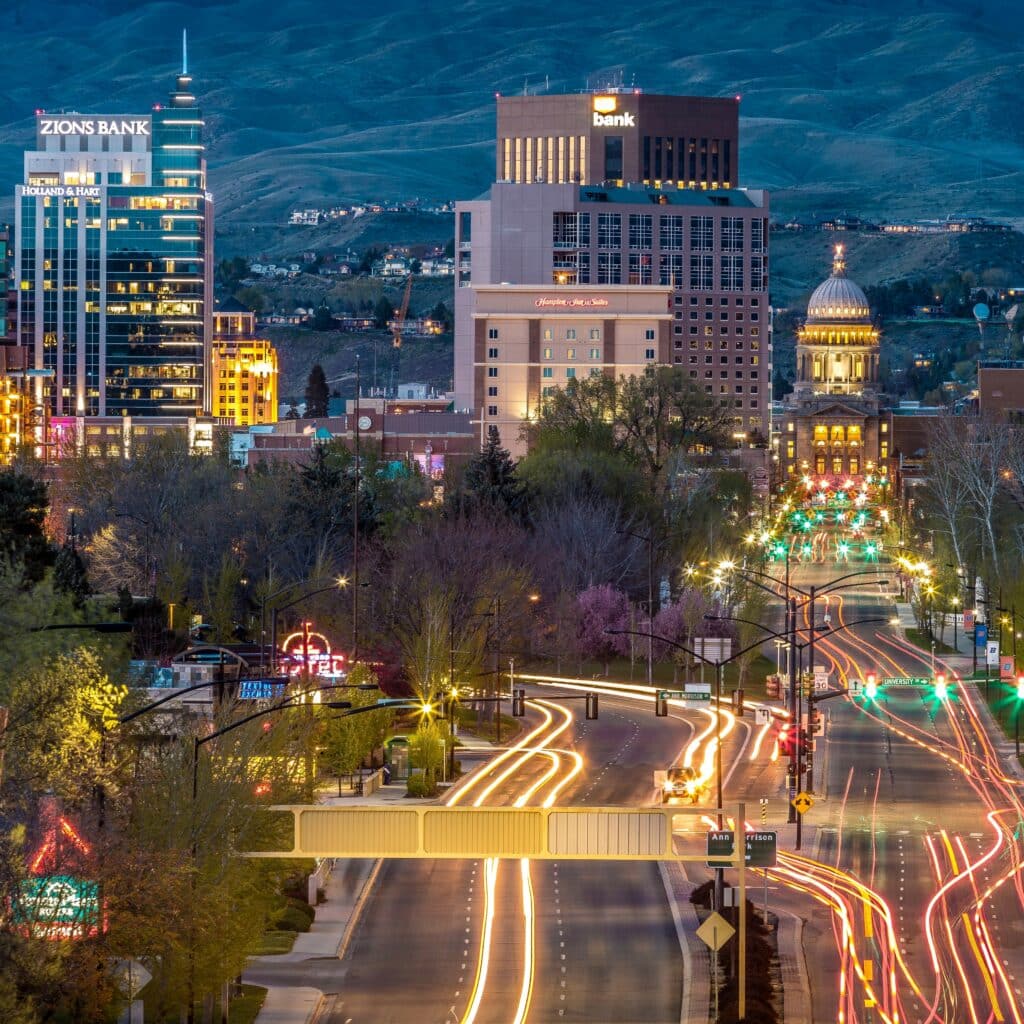 Boise, Idaho at nighttime, revealing city buildings and bright lights from traffic on major roads.