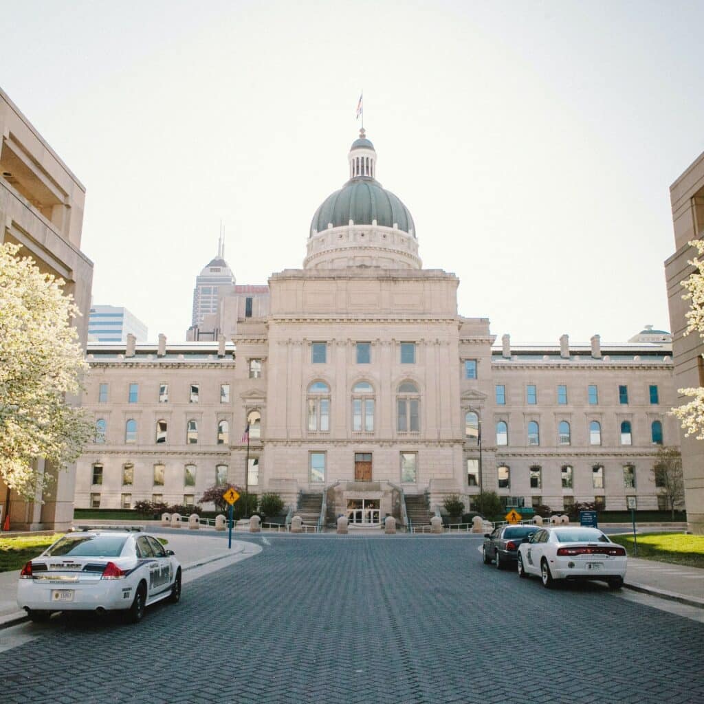 White police cars parked on the side of the Indiana Statehouse in Indianapolis.