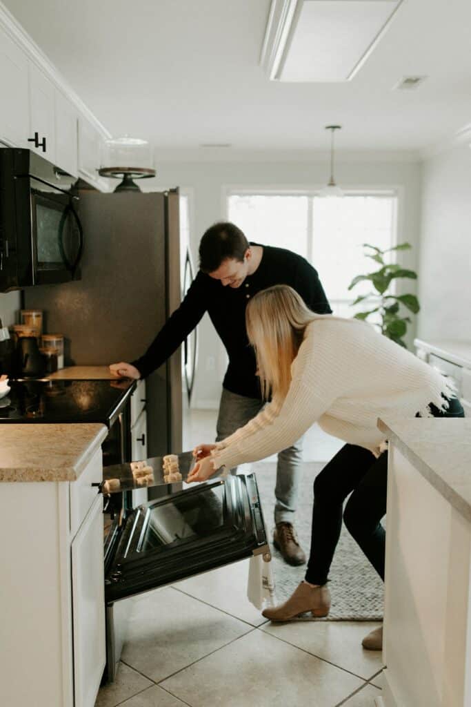 couple pulling baking out of oven