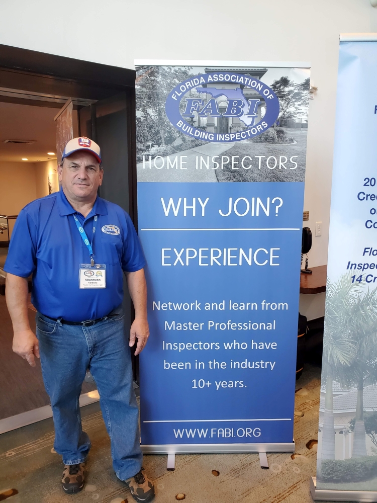 Vince Cardone in front of the Florida Association of Building Inspectors (FABI) sign.