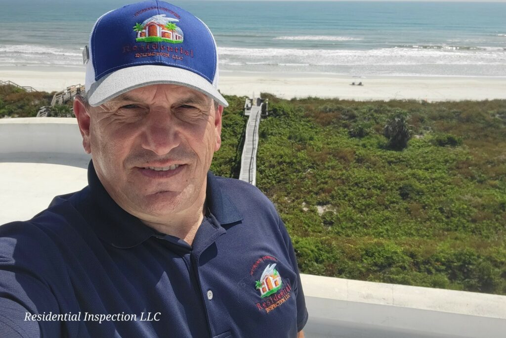 Photo of home inspector Vince Cardone of Residential Inspection LLC in Florida on a roof by the beach.