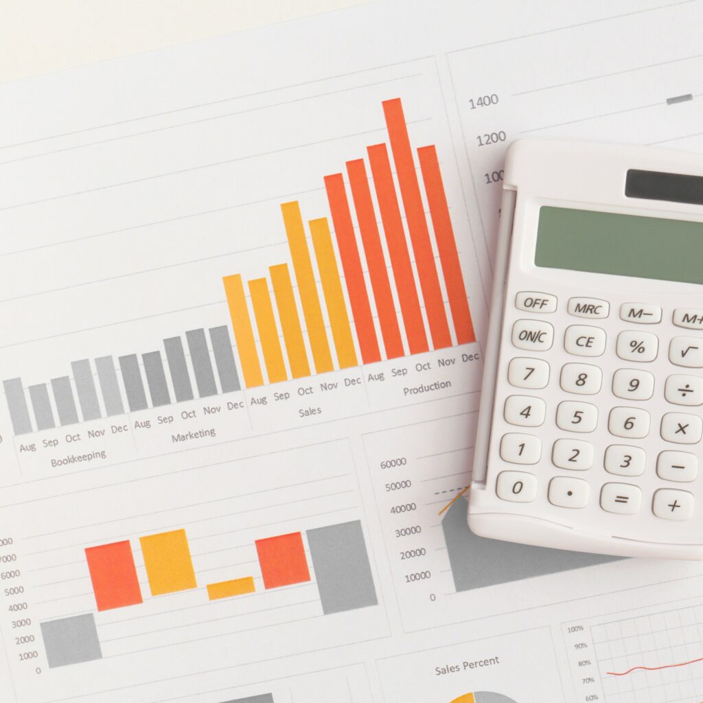 Orange, yellow, and grey charts next to a calculator, implying calculation of the demand for home inspectors.