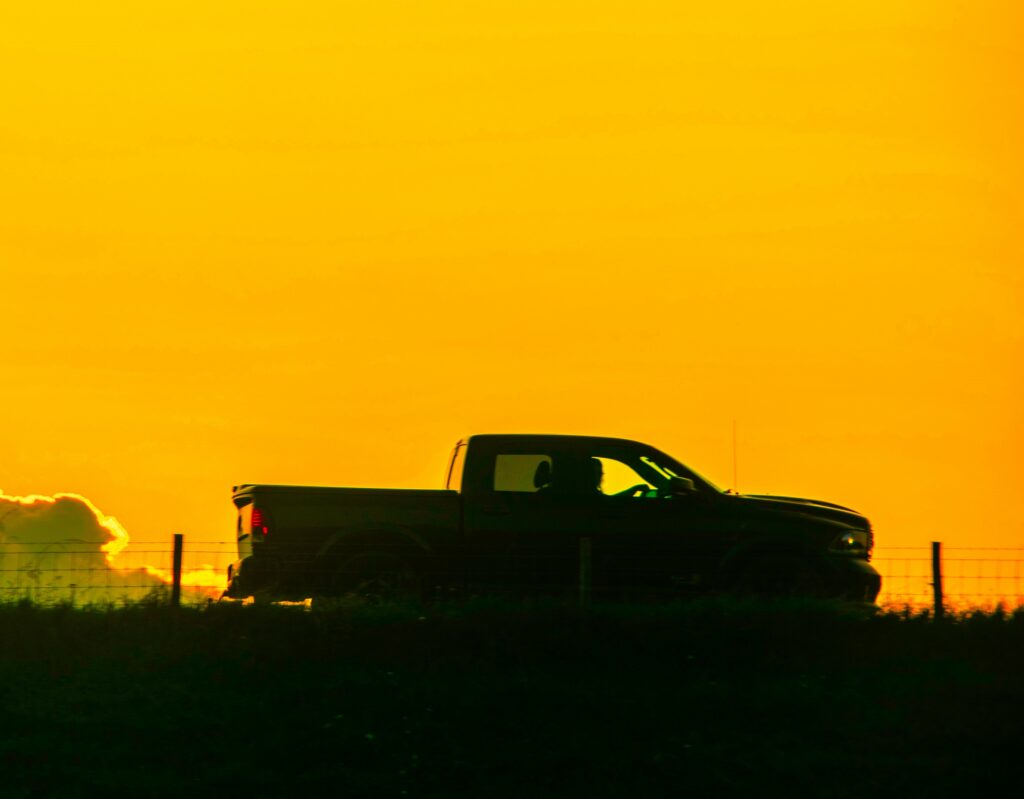 Home inspector hours vary depending on your commute, as shown with this truck driving against a bright yellow sunrise or sunset.