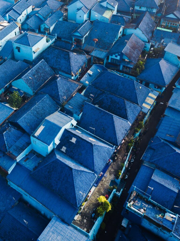 Overhead shot of neighborhood with blue houses and rooftops. 