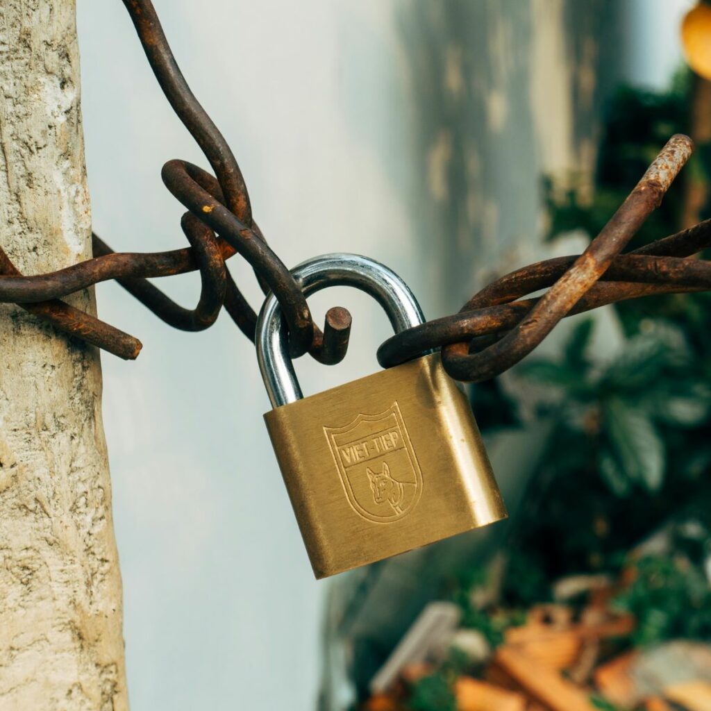 A golden lock connecting two rusty chains. Used to symbolizing the security and strength of getting insurance for your home inspection business.
