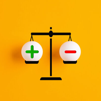 Illustration of a black scale against a yellow background, with a green plus sign on the left and a red minus sign on the right. Used to illustrate asking if home inspector is a good career and weigh the pros and cons of being a home inspector.