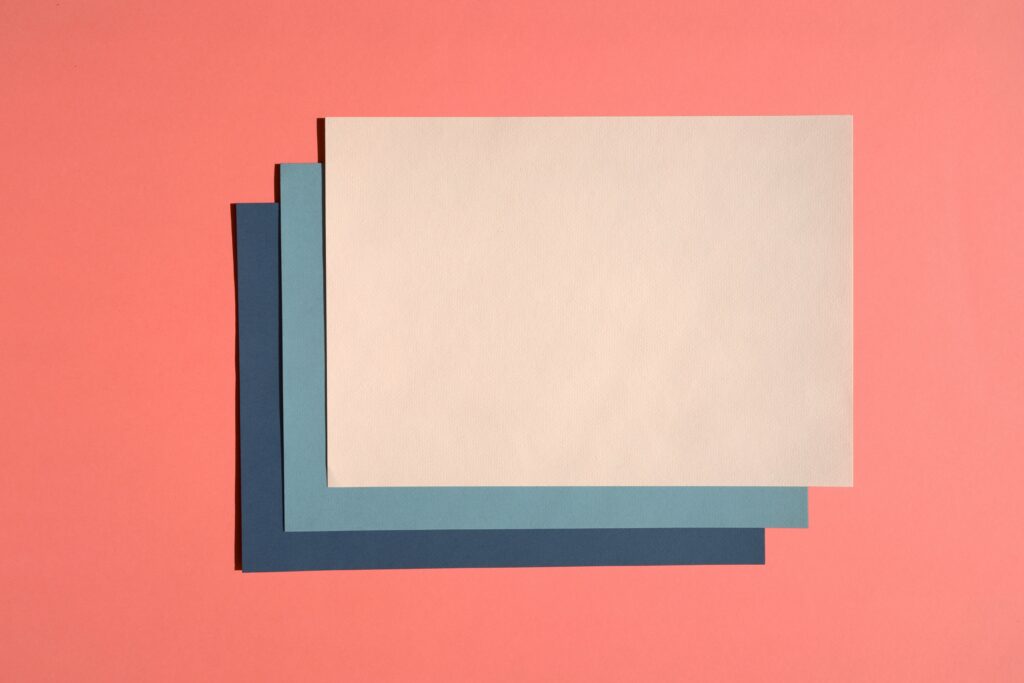 Three pieces of differently colored paper stacked on top of each other, like separate contracts for separate services.